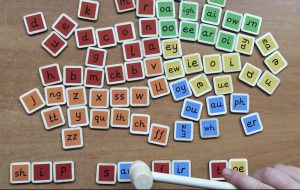 This new toy can be used with our colour coded flash card book to: MAKE,  TAP and BLEND hundreds of words. It is fully systematic for phases 2-5 (approximately years reception to year 2). You will receive: 73 colour mapped wooden tiles and a small wooden hammer in a zip up bag.